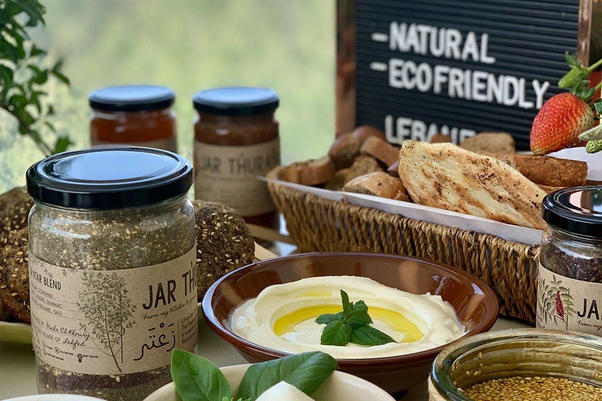 Jar Thuraya products on a table along with a plate of labneh.